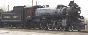 a large steam locomotive painted black with yellow numbers that say "Canadian Pacific 1201"