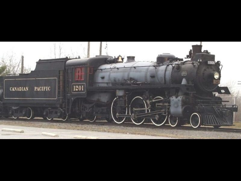 a large steam locomotive painted black with yellow numbers that say 